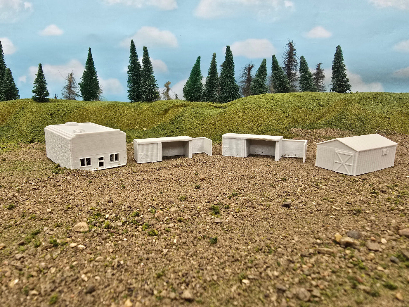 Model buildings on a landscape with trees and sky in the background