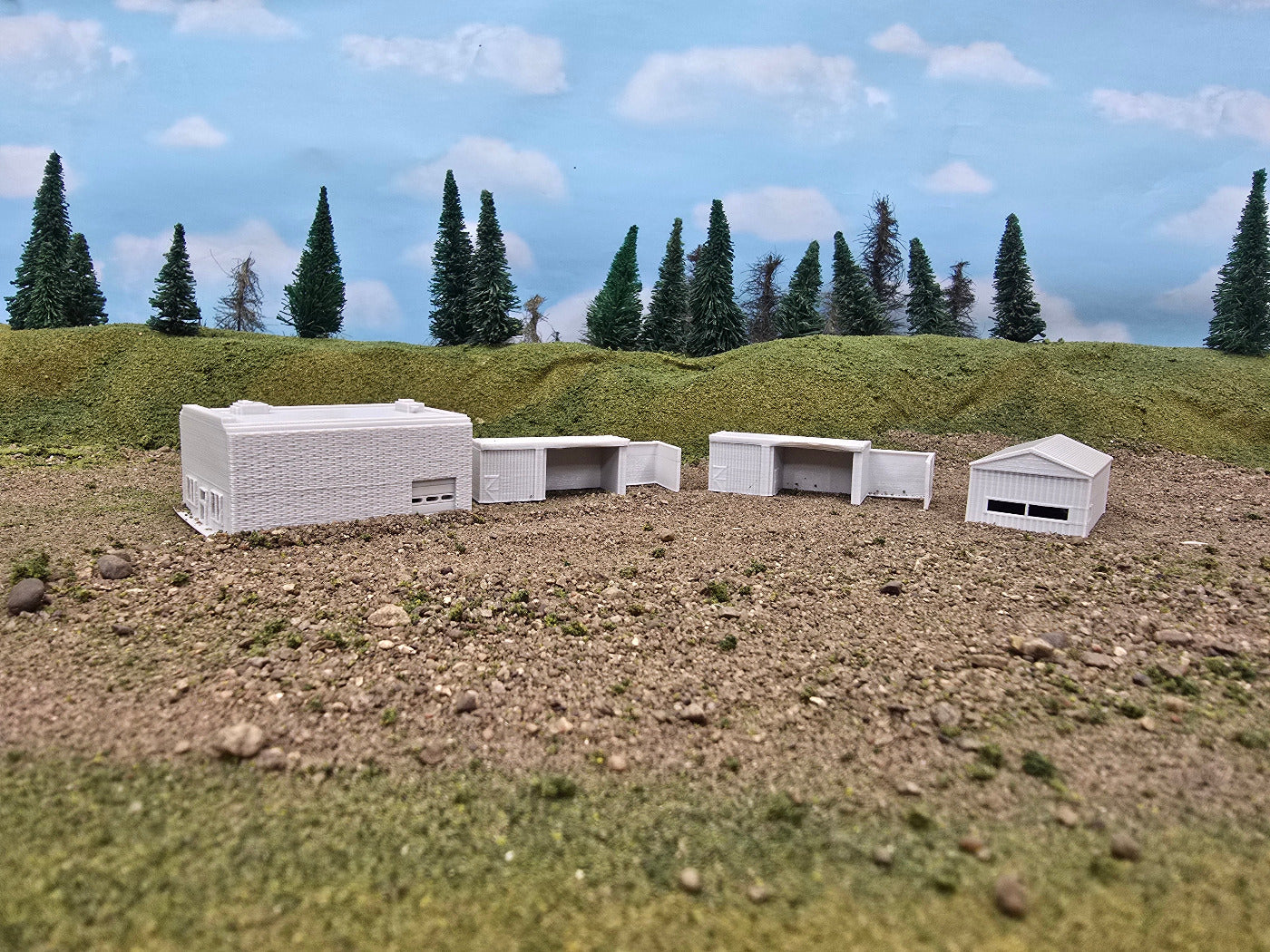 Model buildings on a landscape with trees and sky in the background
